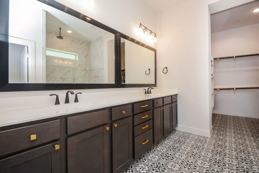 A private extension of the primary suite, this elegant bathroom features dual vanities, contemporary finishes, and direct access to a spacious walk-in closet. Unwind in the oversized walk-in shower featuring a luxurious rainfall showerhead, creating a true spa-like experience at home. Filled with natural light and designed for both comfort and functionality, this inviting retreat transforms everyday routines into moments of relaxation and effortless luxury.