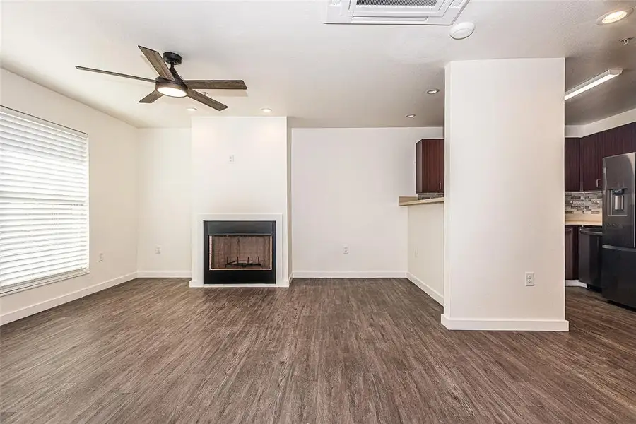 living room featuring luxury vinyl wood-style flooring, ceiling fan, and a healthy amount of sunlight