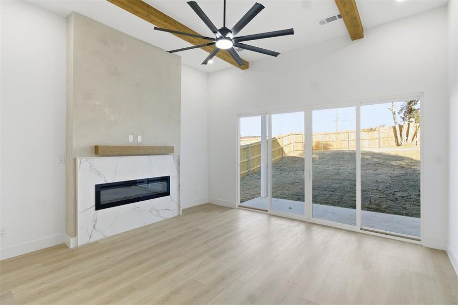 Unfurnished living room with ceiling fan, a fireplace, and wood finished floors