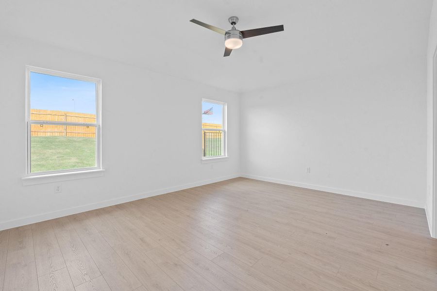 Empty room with light wood finished floors and ceiling fan