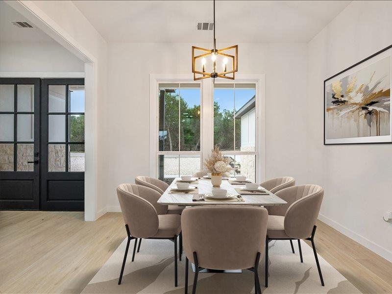 The dining area features light-toned flooring, a window offering exterior views, and a contemporary chandelier
