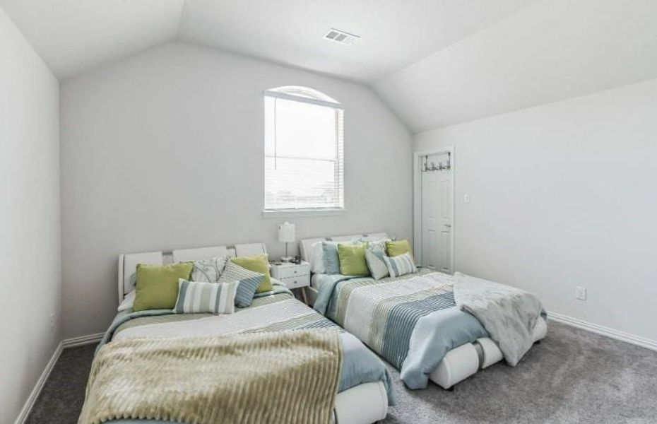 Bedroom with vaulted ceiling and carpet floors