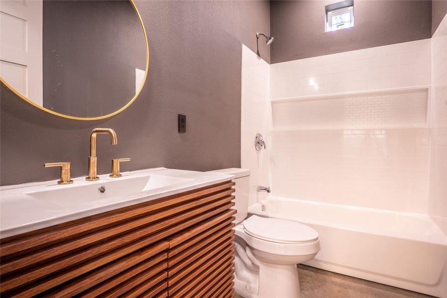 Full bathroom featuring shower / bath combination, vanity, and a textured wall