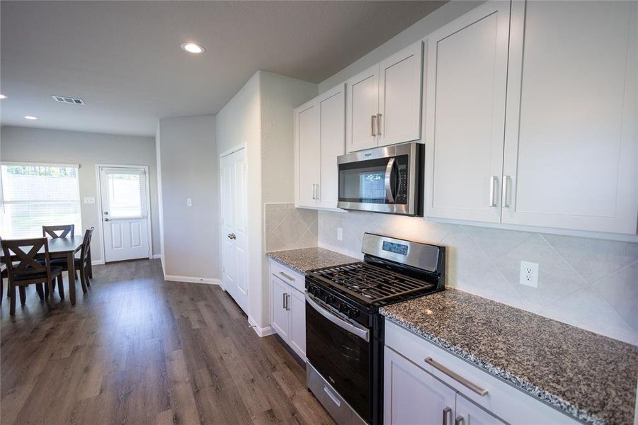 Stunning kitchen featuring granite countertops, modern cabinetry, and stainless steel appliances.
