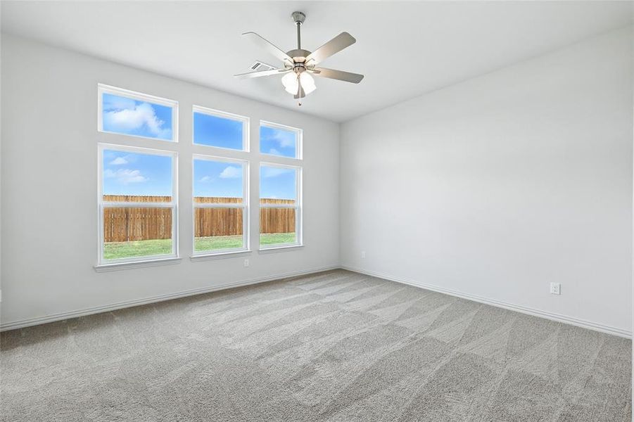 Carpeted spare room featuring baseboards and a ceiling fan Carpeted spare room featuring baseboards and a ceiling fan
