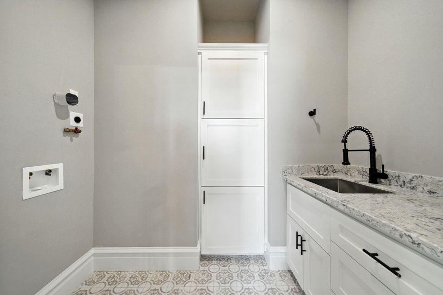 Utility room on the second floor with storage, stainless steel sink and granite counters / folding space! Stacking washer / dryer will go on the left Utility room on the second floor with storage, stainless steel sink and granite counters / folding space! Stacking washer / dryer will go on the left