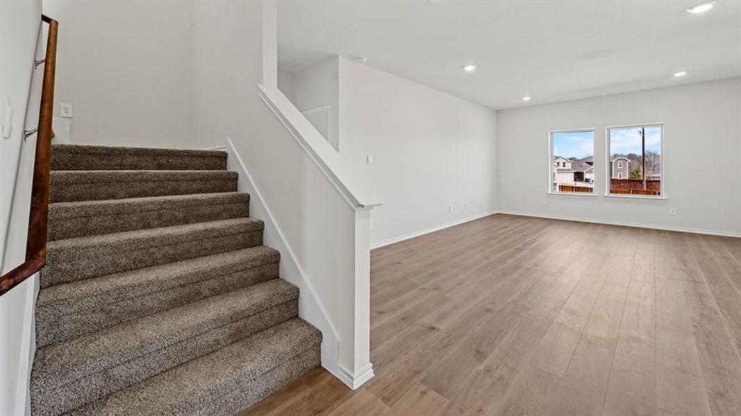 Stairway with wood finished floors and recessed lighting