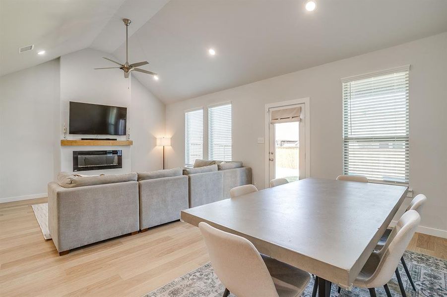 Dining area with light wood-style floors, high vaulted ceiling, ceiling fan, and recessed lighting Dining area with light wood-style floors, high vaulted ceiling, ceiling fan, and recessed lighting