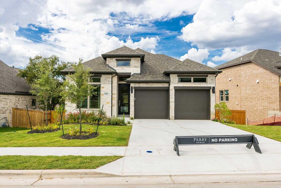 View of front of home with stone siding, a shingled roof, driveway, and a garage View of front of home with stone siding, a shingled roof, driveway, and a garage