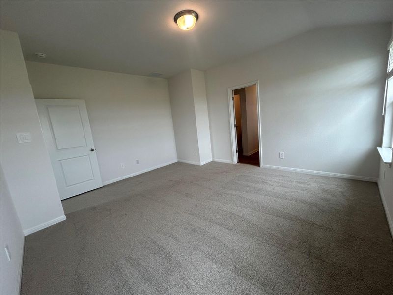 Empty room with carpet floors and vaulted ceiling