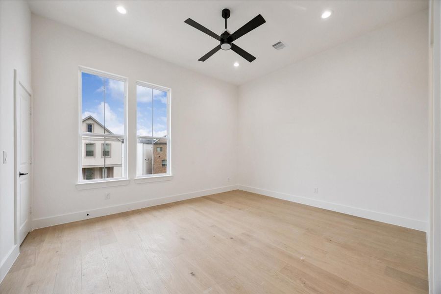 The primary bedroom features soaring ceilings and ample space for relaxing in privacy.