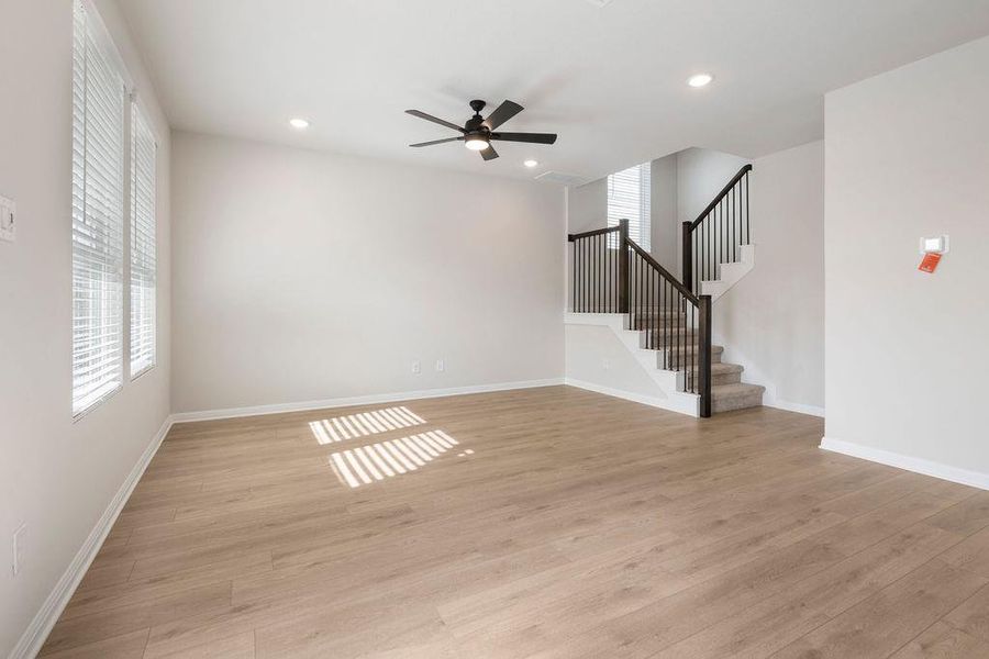 Unfurnished living room featuring light wood-style flooring, a ceiling fan, and recessed lighting