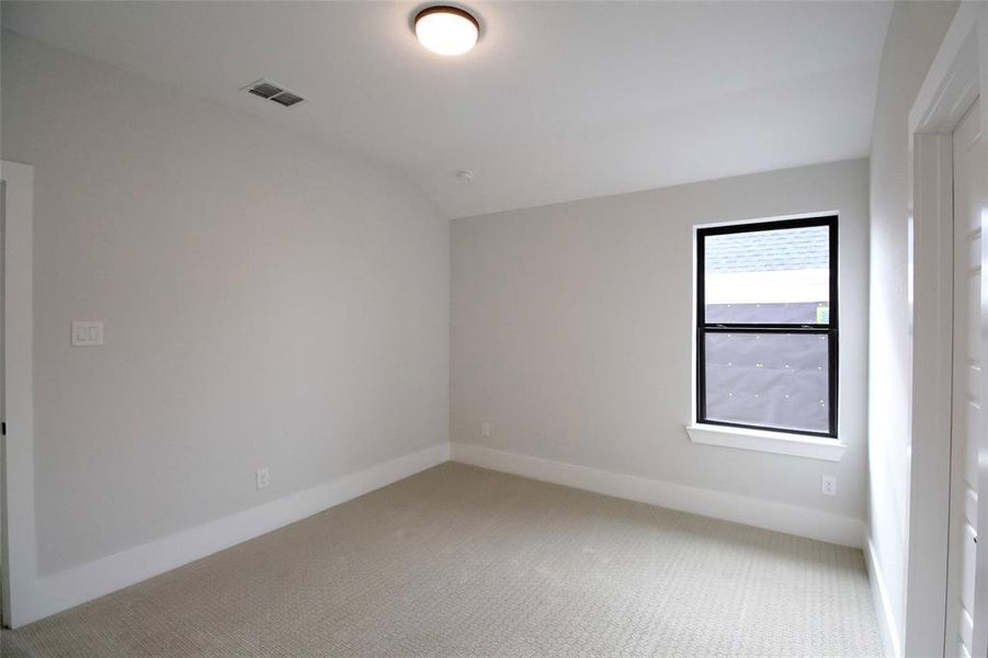 Carpeted empty room with vaulted ceiling