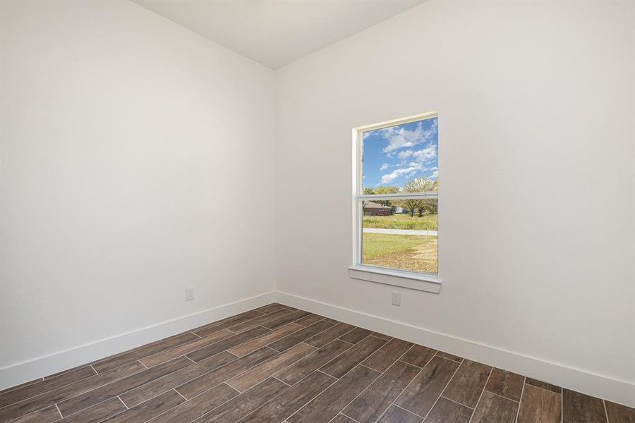Spare room with baseboards and wood finish floors