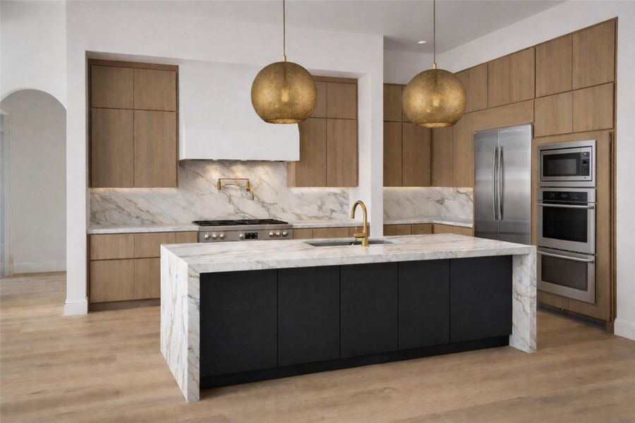 Kitchen featuring light stone counters, modern cabinets, a large island, and two tone cabinetry