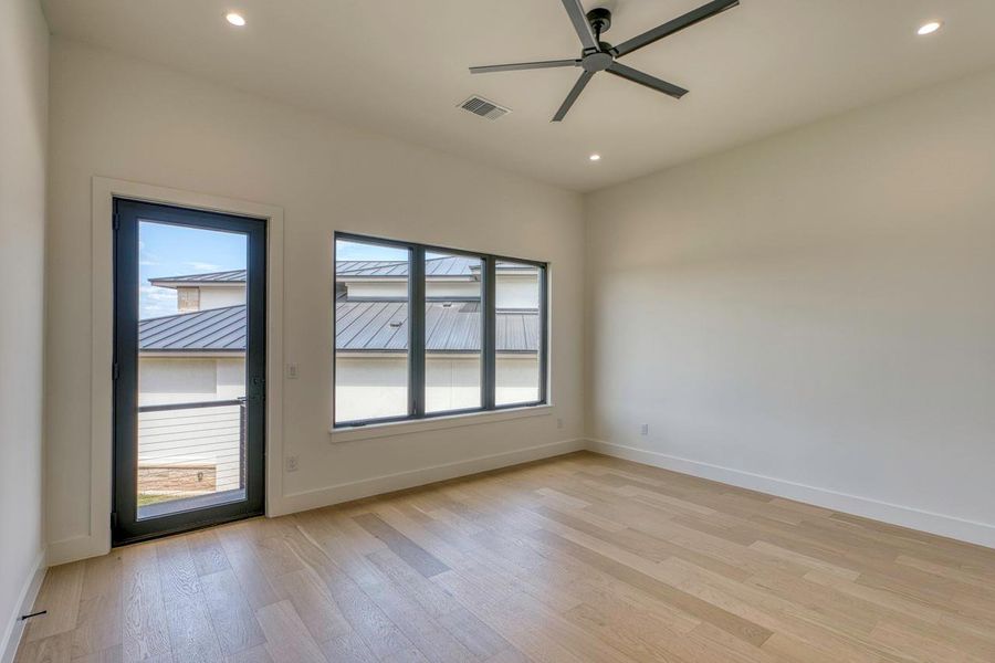 Clean lines and warm hardwood floors define this serene, minimalist bedroom space.