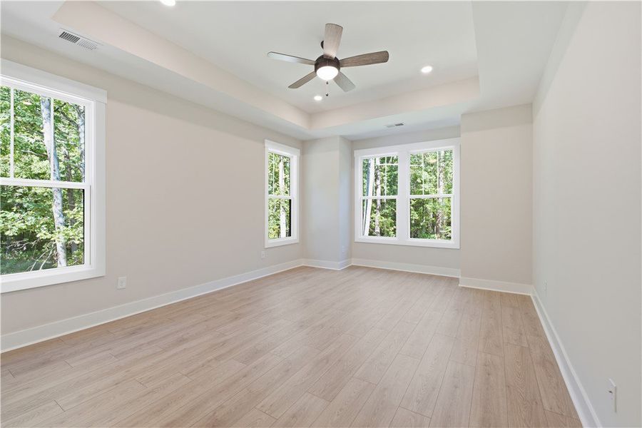 An elegant tray ceiling and rich wood floors frame