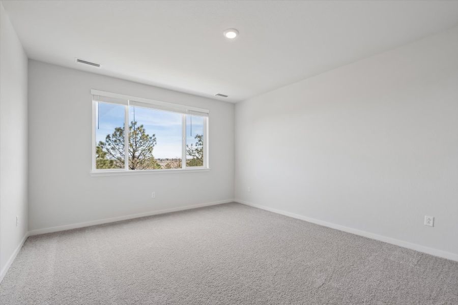 A room with a window and a white wall.
