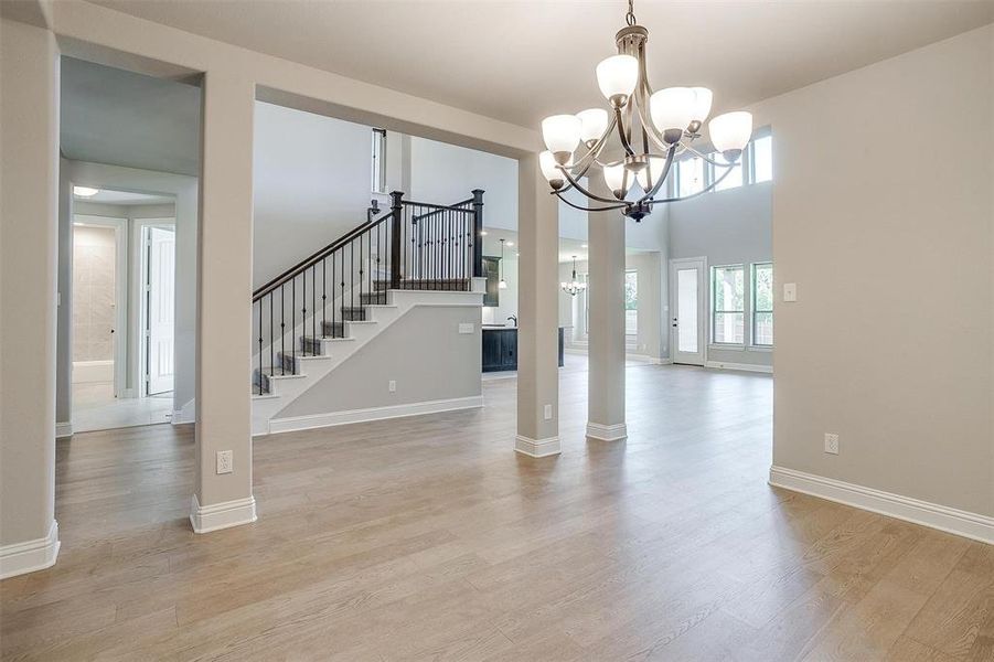 Unfurnished dining area featuring light hardwood / wood-style floors and an inviting chandelier