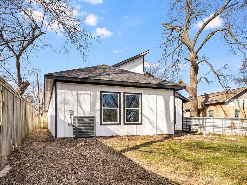 Back of property featuring central AC unit and a lawn