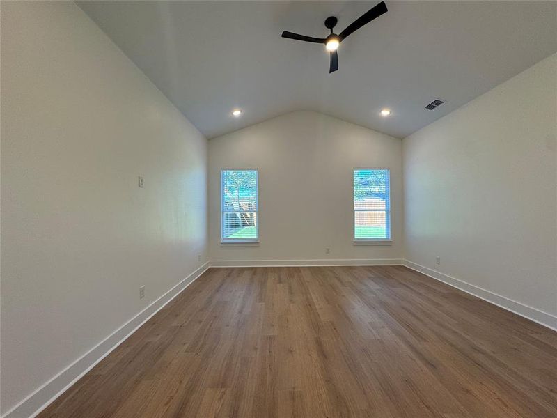 Unfurnished room featuring light hardwood / wood-style floors, ceiling fan, and vaulted ceiling