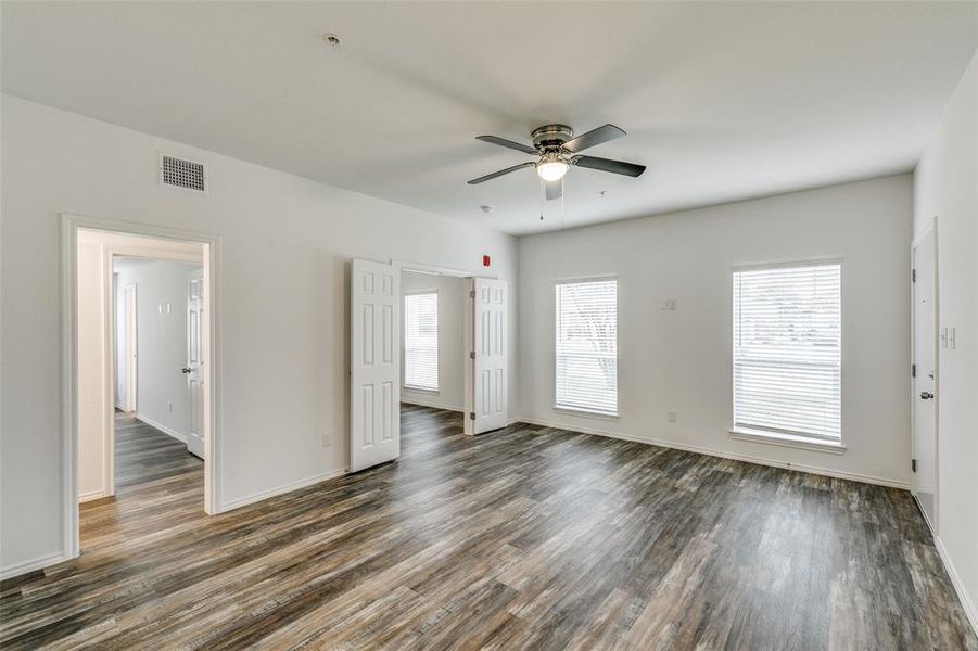 Unfurnished room featuring dark wood-type flooring and ceiling fan