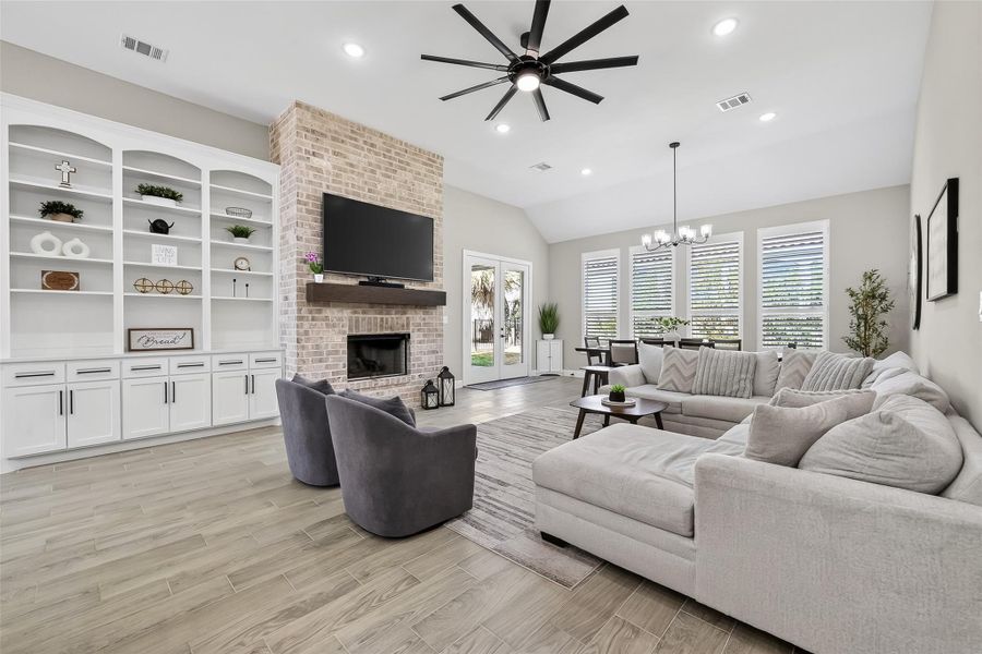 Open living room featuring built-in shelving and fireplace focal point. Open living room featuring built-in shelving and fireplace focal point.