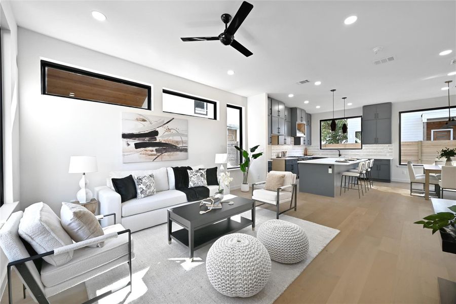 Living room featuring light hardwood / wood-style floors, sink, ceiling fan, and a healthy amount of sunlight