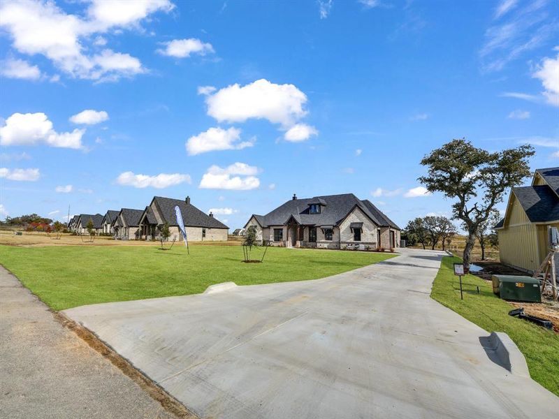 French country inspired facade featuring a front lawn