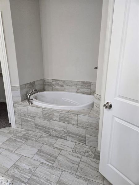 Bathroom featuring tile flooring and tiled bath