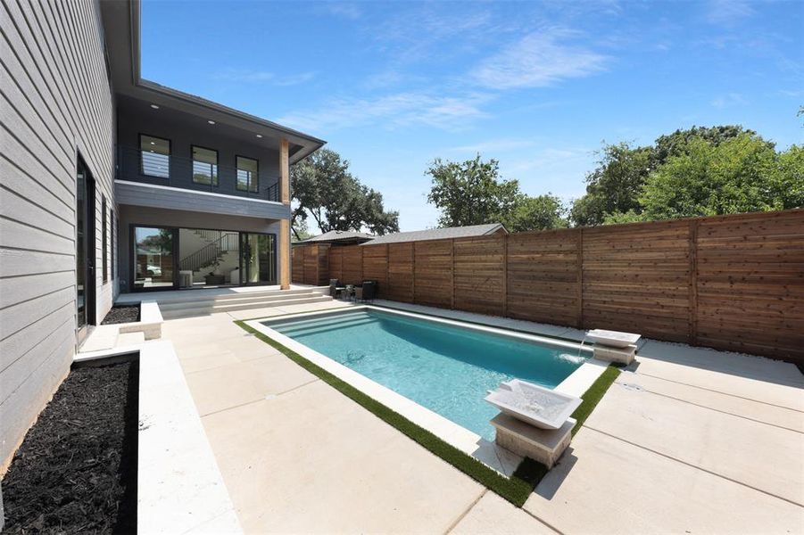 View of pool featuring a fenced backyard, a patio, and a balcony