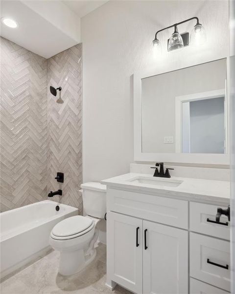 Full bathroom with vanity, toilet, and tiled shower / bath