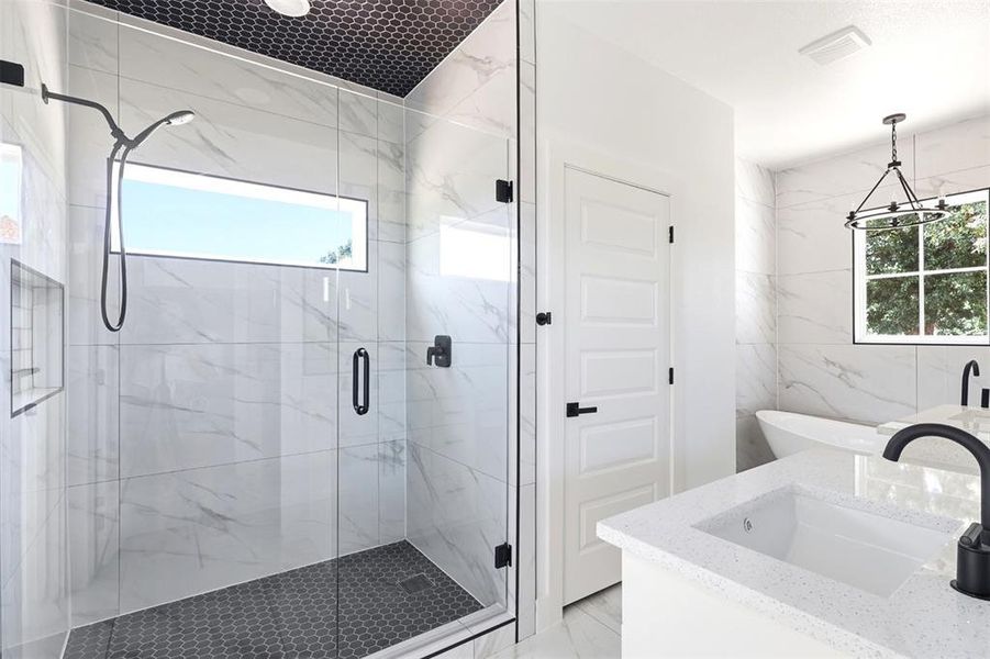Bathroom featuring a frameless glass shower enclosure with matte black fixtures, an integrated shower niche, and a horizontal transom window