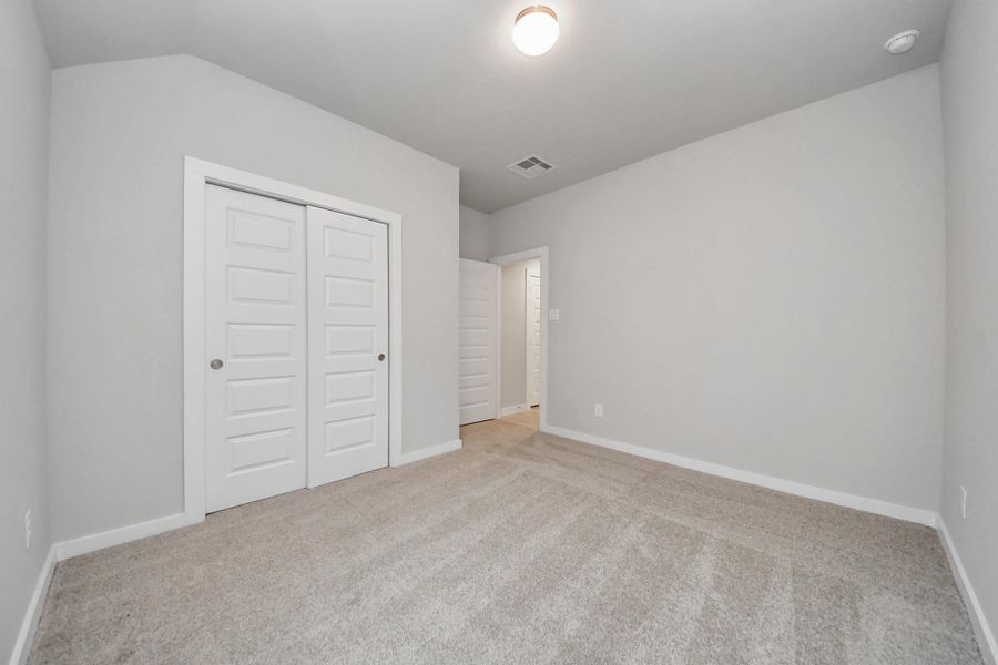 Generously sized secondary bedrooms featuring spacious closets, soft and inviting carpeting underfoot, large windows allowing plenty of natural light, and the added touch of privacy blinds for your personal retreat. Sample photo of completed home with similar floor plan. Actual colors and selections may vary.