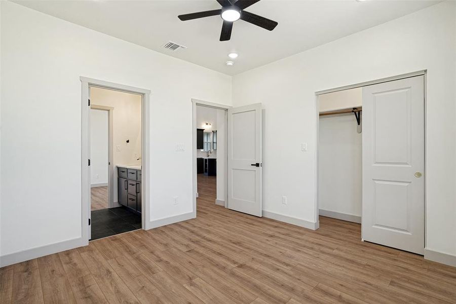 Bedroom 2 featuring wood-finish flooring, a ceiling fan, recessed lighting, and a closet with sliding doors with shared en-suite jack and jill bathroom
