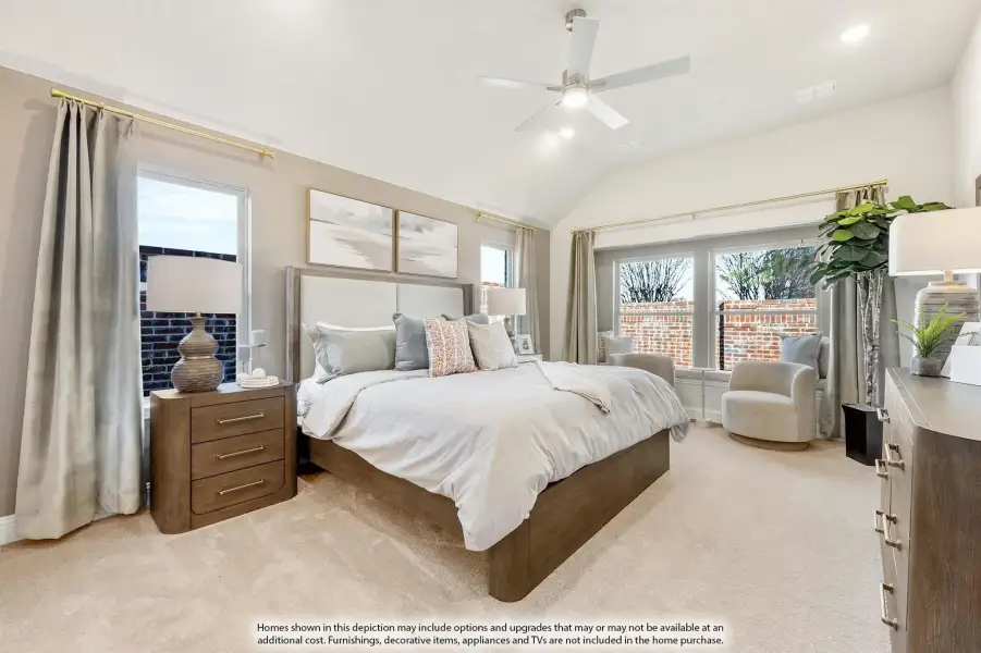 Bedroom with vaulted ceiling, ceiling fan, king bed, carpet floors, and large windows with natural light