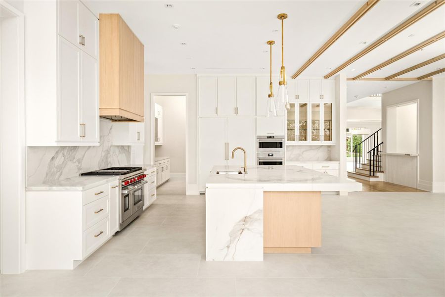 Premium Wolf and Sub-Zero appliances pair with a statement island and warm wood accents for a polished, modern feel.