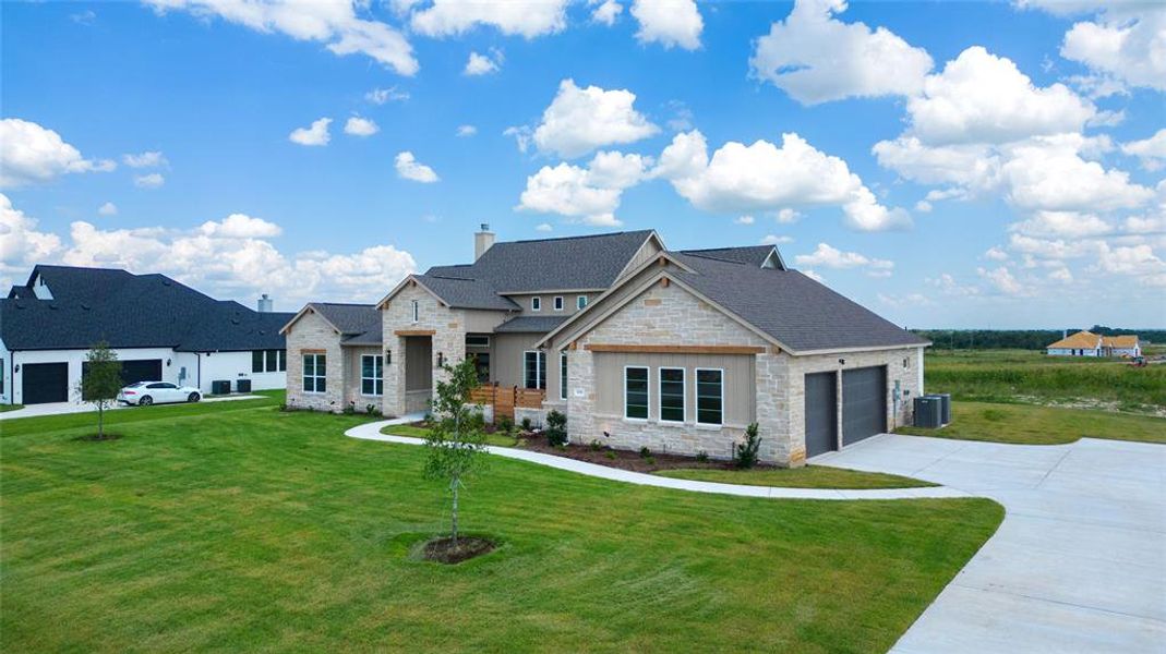 View of front of property with a garage, a front lawn, and central AC unit