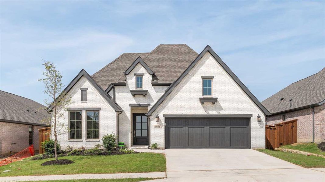 View of front of home with a garage and a front yard