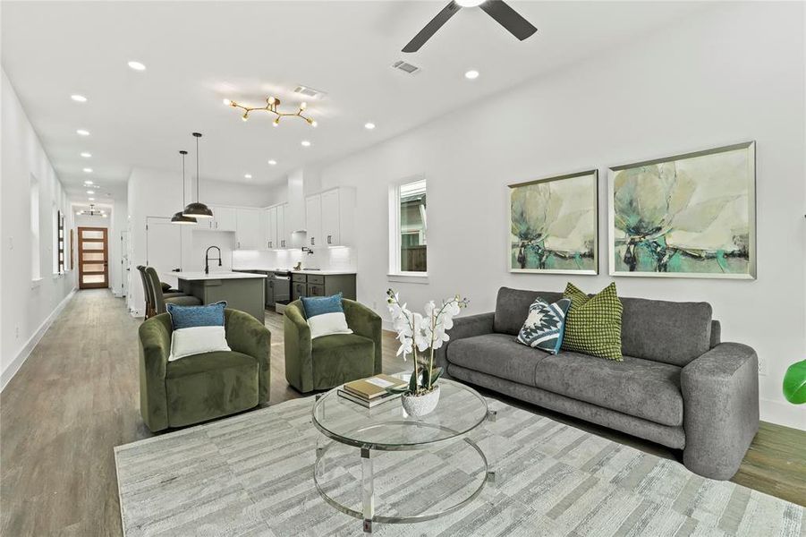Living area with light wood-type flooring, ceiling fan, and recessed lighting