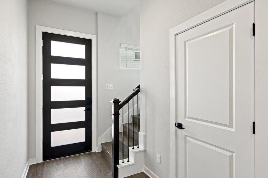 Foyer with dark wood-type flooring and baseboards