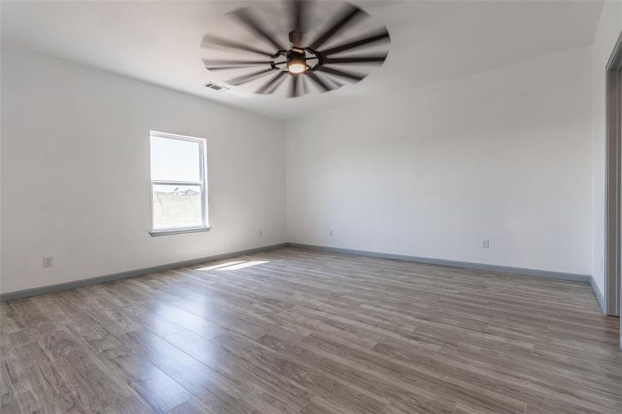 Spare room featuring ceiling fan and light hardwood / wood-style flooring