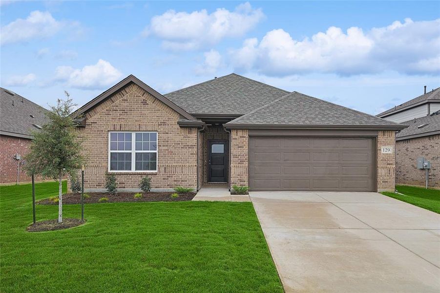 View of front facade featuring a front yard and a garage