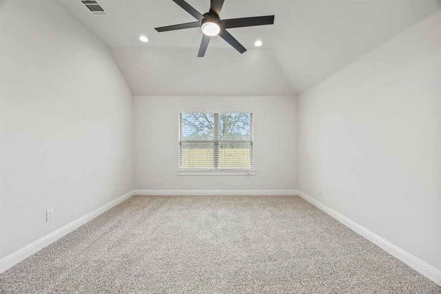 Unfurnished room featuring light carpet, vaulted ceiling, a ceiling fan, and recessed lighting