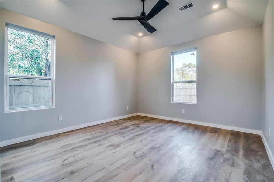 Spare room featuring ceiling fan, plenty of natural light, light hardwood / wood-style floors, and lofted ceiling