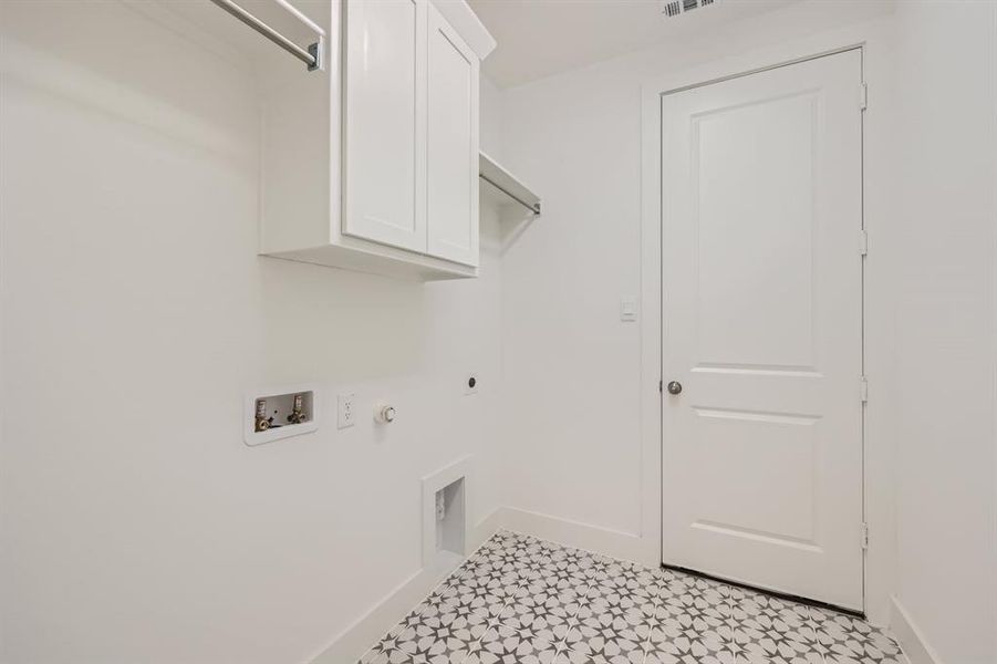 Washroom featuring light tile patterned flooring, hookup for an electric dryer, hookup for a gas dryer, cabinets, and washer hookup