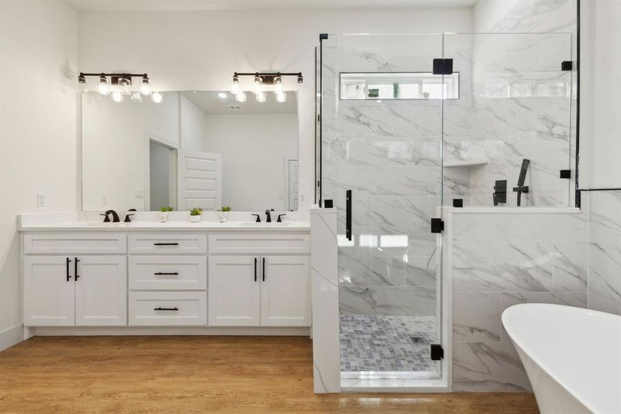 Bathroom with vanity, hardwood / wood-style floors, and separate shower and tub