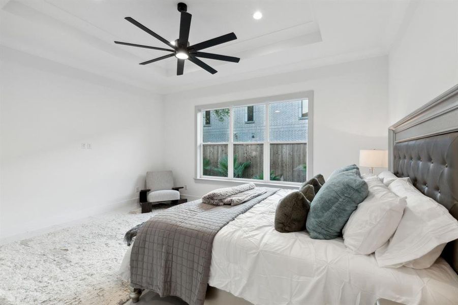 Bedroom with ceiling fan, carpet floors, a raised ceiling, and crown molding