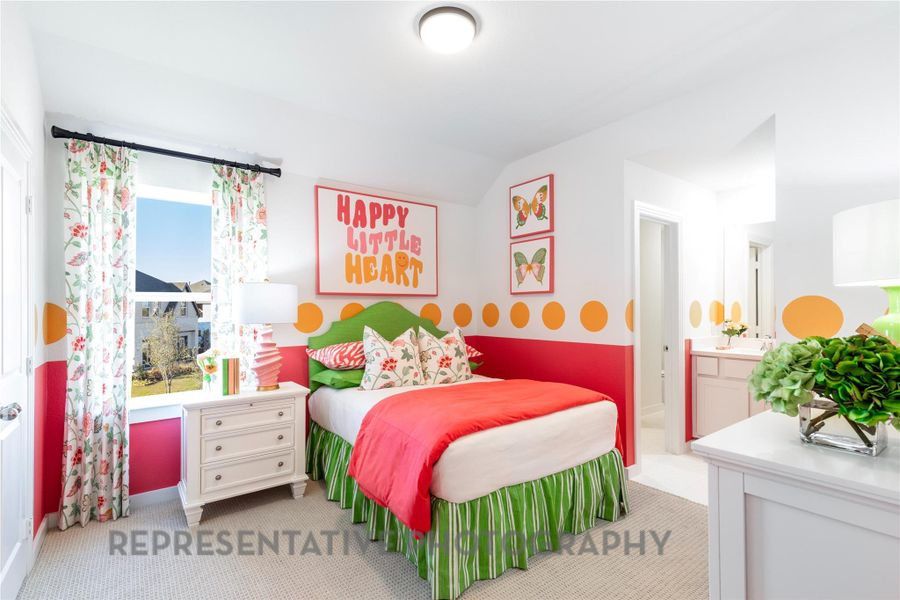 Carpeted bedroom featuring vaulted ceiling and ensuite bathroom