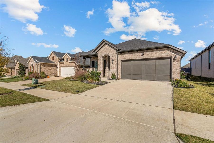 View of front of home featuring a front lawn and a garage